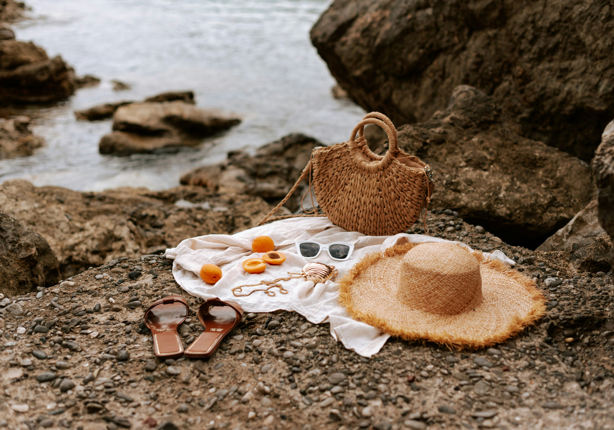 Beach accessories flatlay on rocks