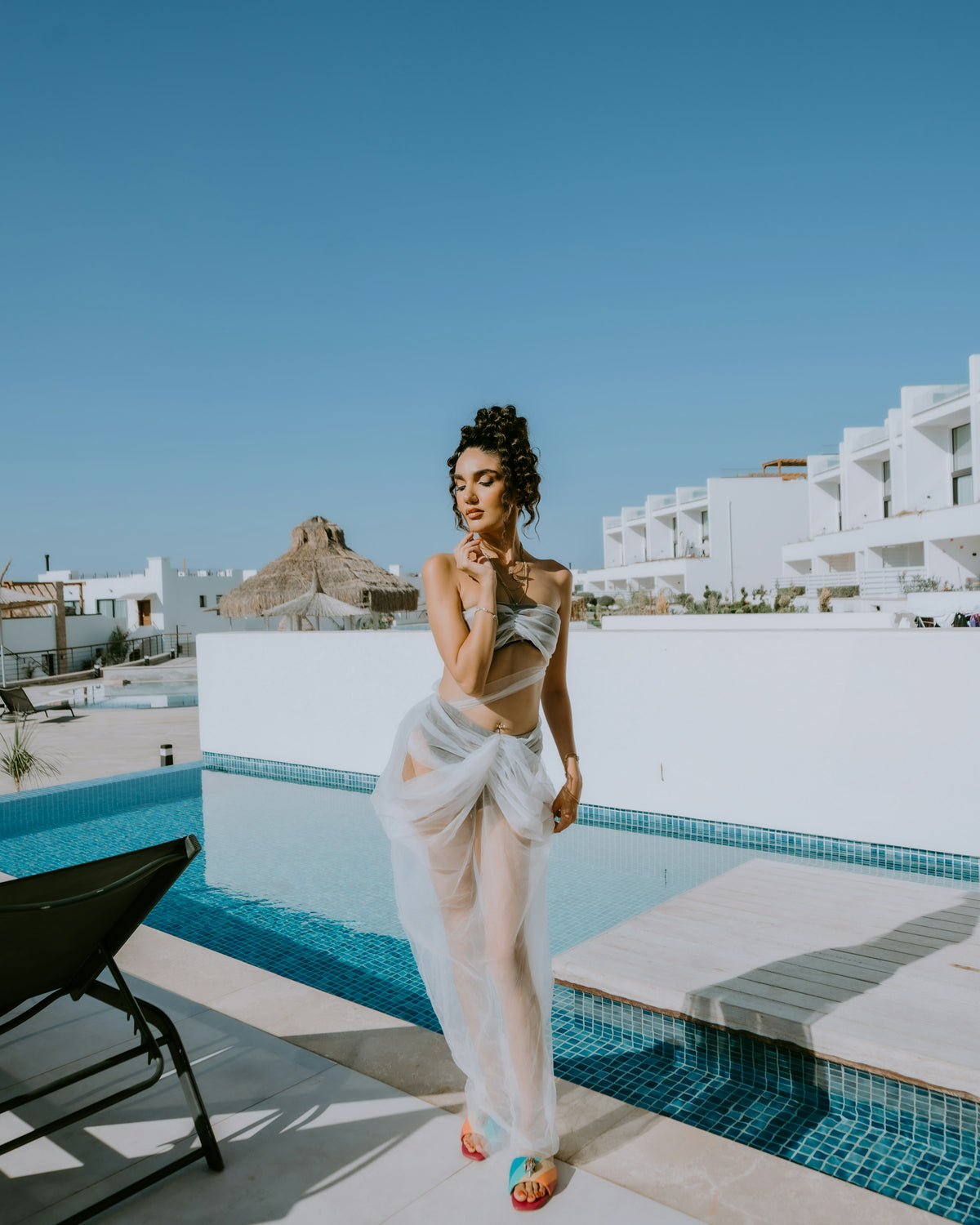 Woman in swimwear cover-up by a resort pool